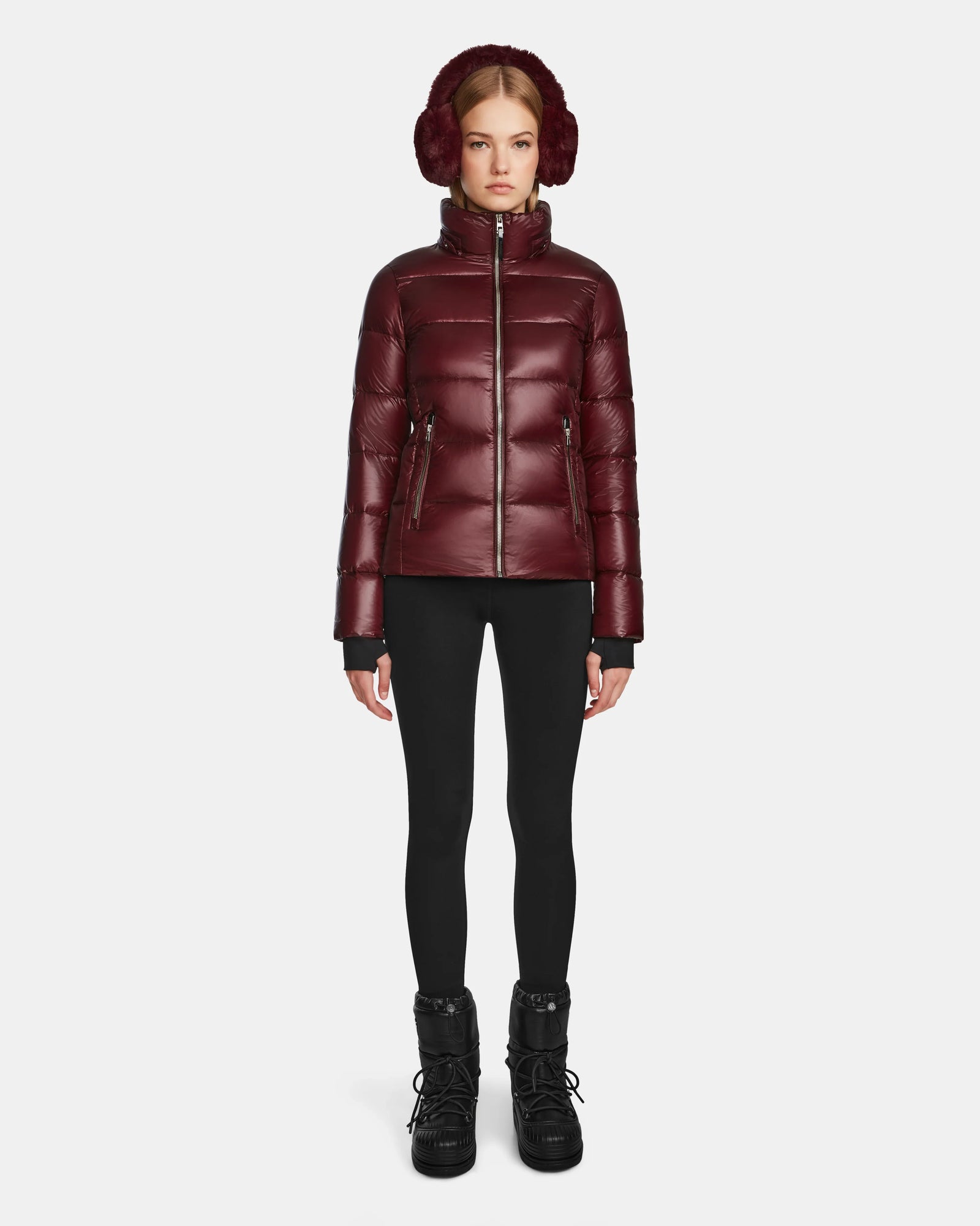 A woman wearing the Rudsak MIRRY S - L123545 Wine quilted down coat and black pants.