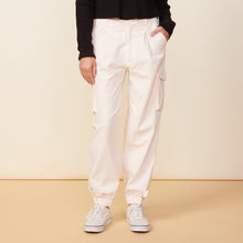 Front view of model wearing the utility pants in off white.