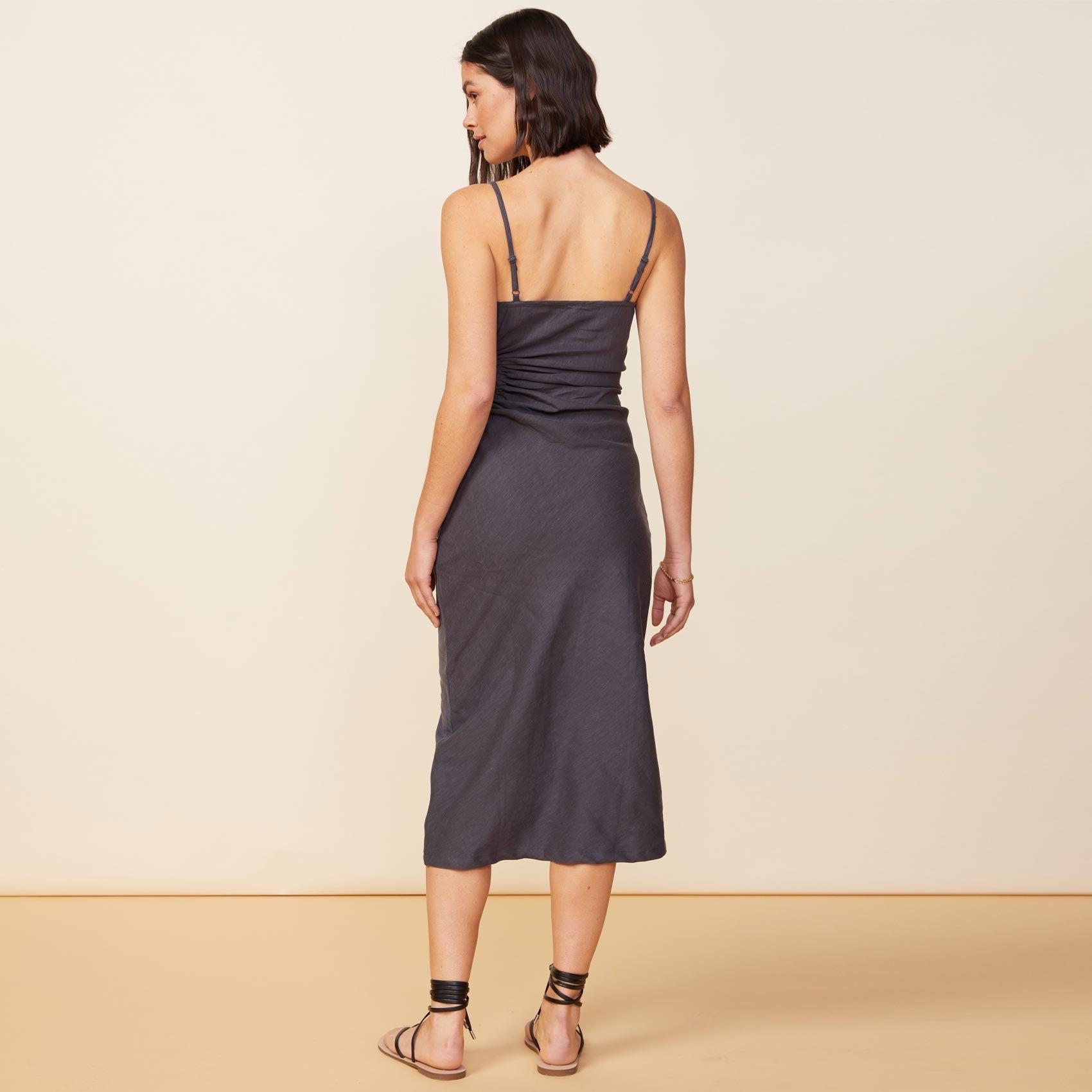 Back view of model wearing the linen slip dress in faded black.