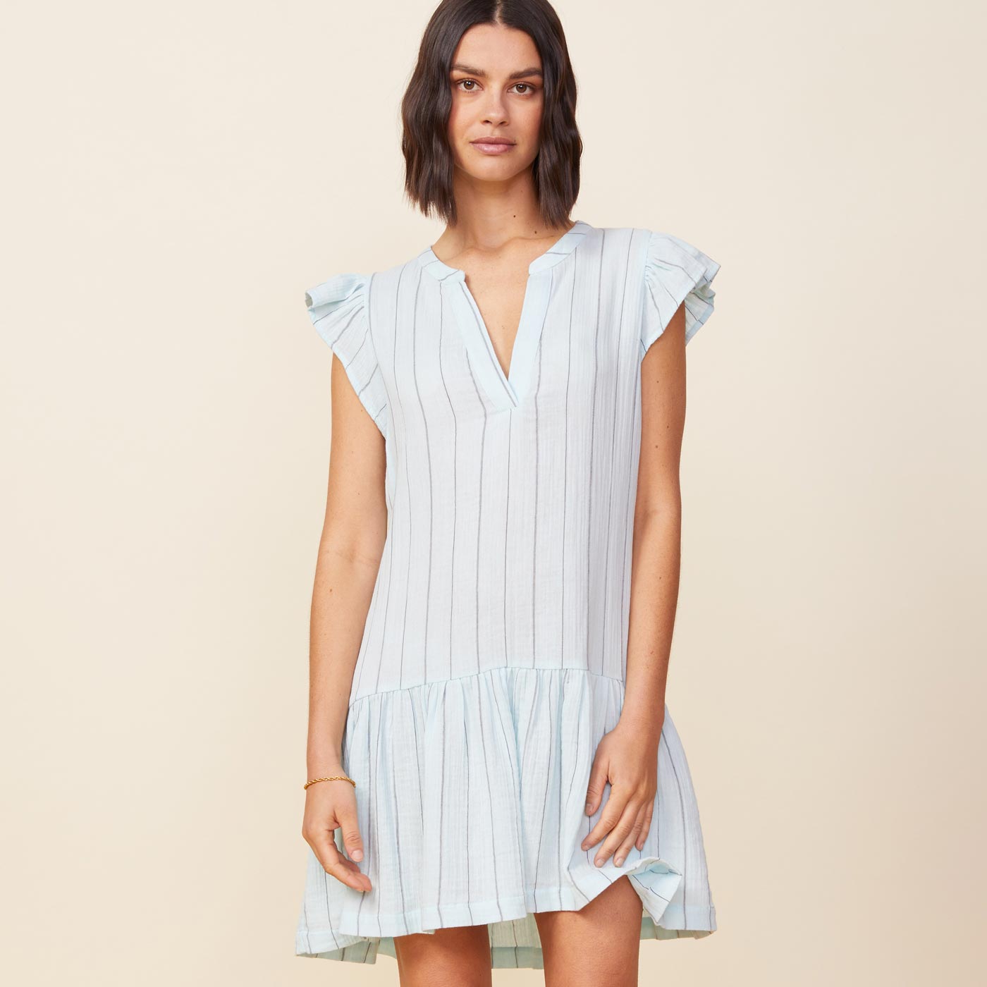 Front view of model wearing the pinstripe gauze easy ruffle dress in sea foam.