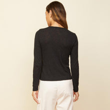 Back view of model wearing the asymmetric long sleeve top in black.