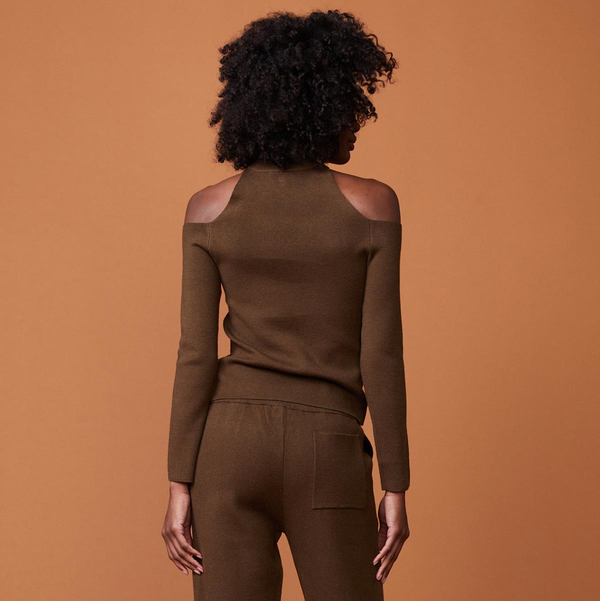 Back view of model wearing the supersoft sweater knit cold shoulder top in moss.