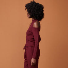 Side view of model wearing the supersoft sweater knit cold shoulder top in rhubarb.