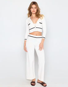 Woman wearing a white outfit with black accents on a white background