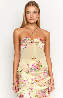 Close-up of the yellow floral strapless top with twisted bust detail, sheer overlay, and midriff cutout