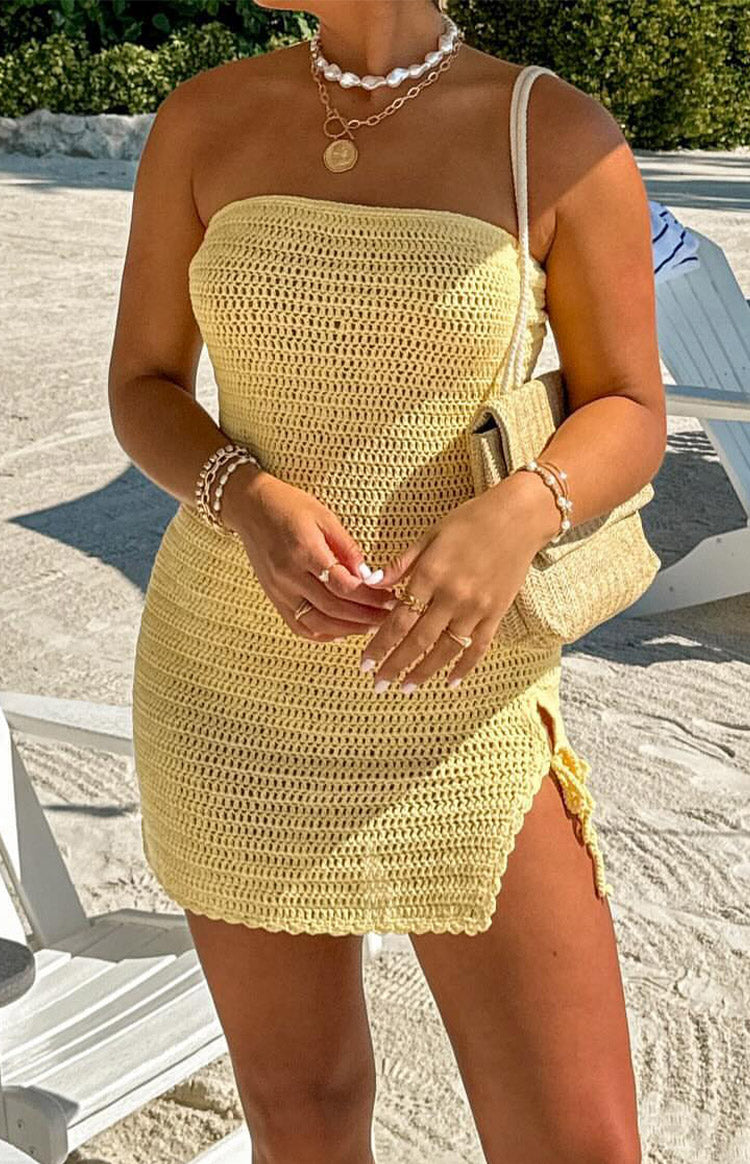 Close-up of the yellow crochet knit mini dress showing the strapless neckline and side tie detail