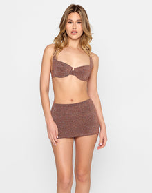 Model wearing the Karter Bralette Top paired with the Casey Mini Skirt in brown shimmer fabric, featuring double waistband detail, from the latest resortwear collectio