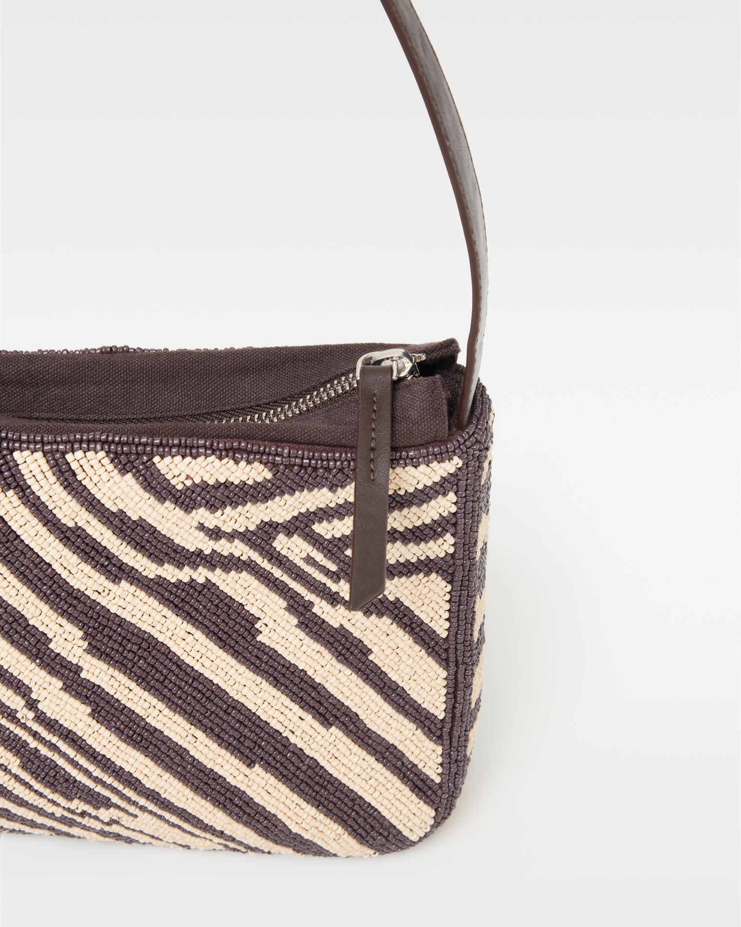 Close-up of the beaded detail and zipper closure on the animal print Alora Bag.