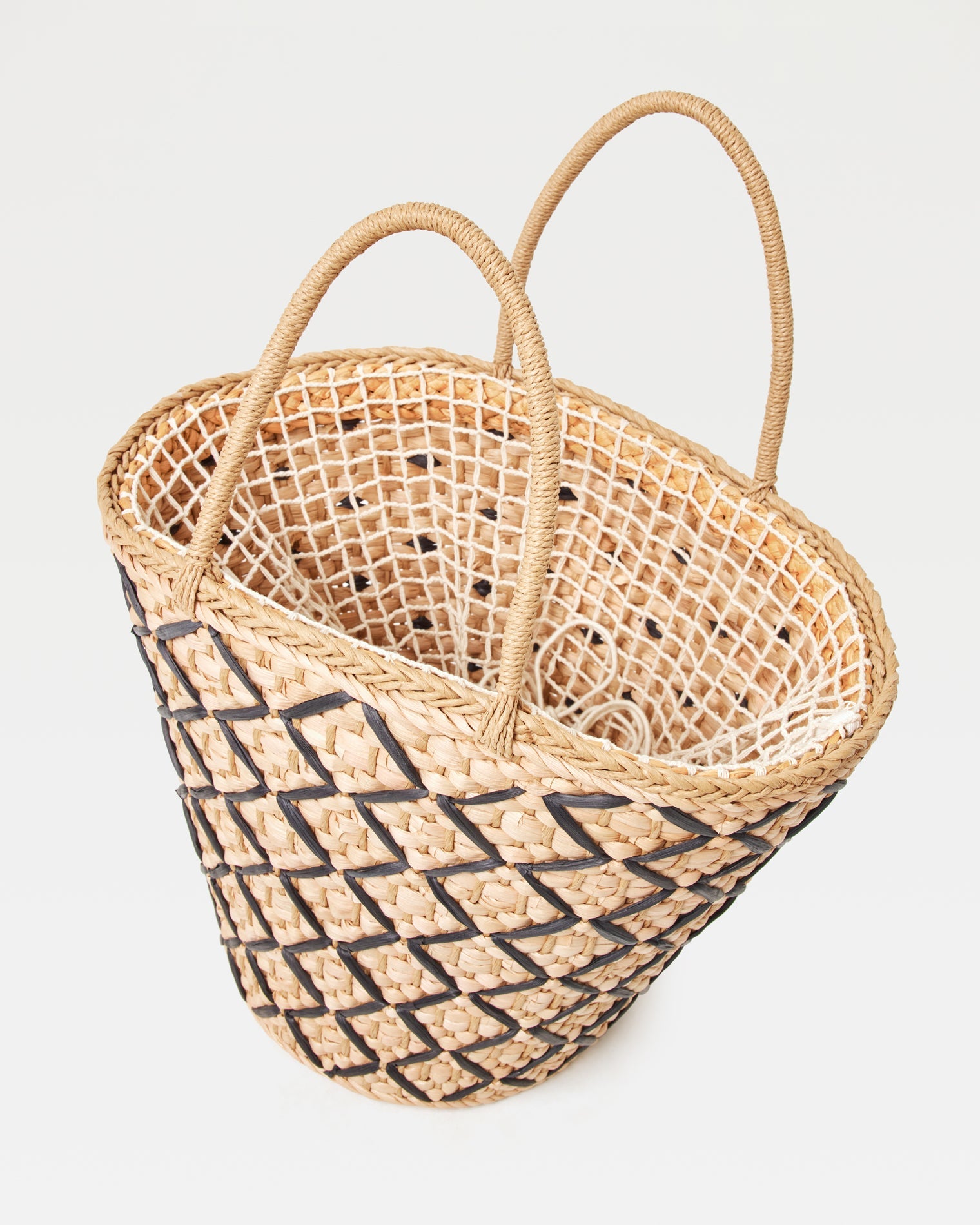 Angled top-down view of the Palma Nights Bag in natural-black showing the open interior and the natural-black lattice weave on the exterior.