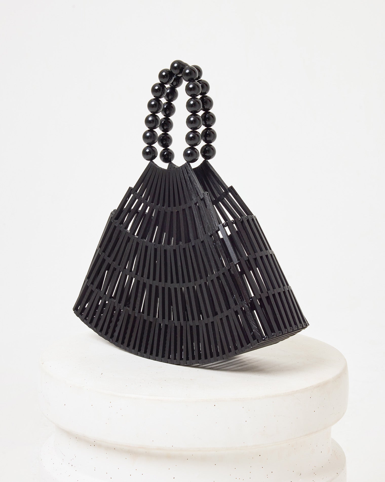 Side view of the Starlight Bag in black on a white pedestal.
