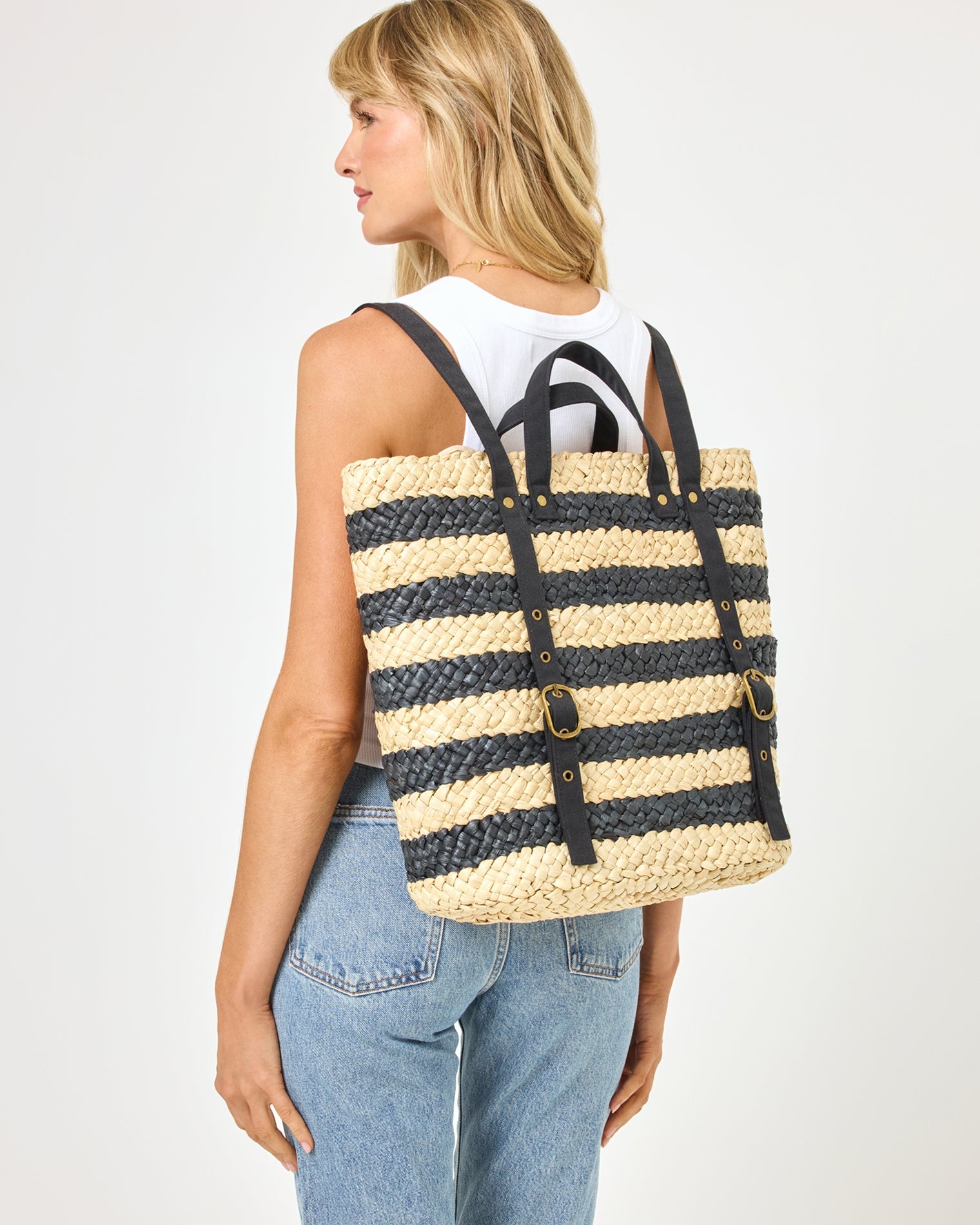 Back view of model wearing the Summer Days Backpack in natural-black, paired with a white tank top and jeans.