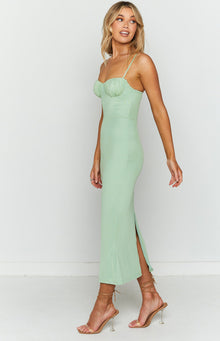Side view of a light green mesh midi dress with a ruched sweetheart neckline and a high side slit