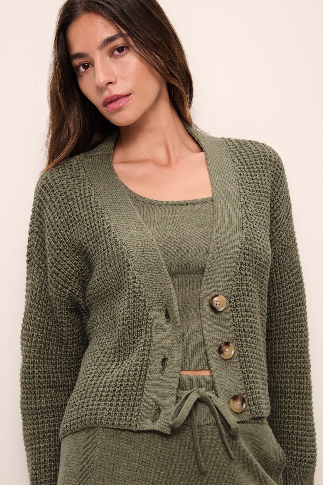 Model is Wearing the Recycled Sweater Cropped Cardigan in Moss.