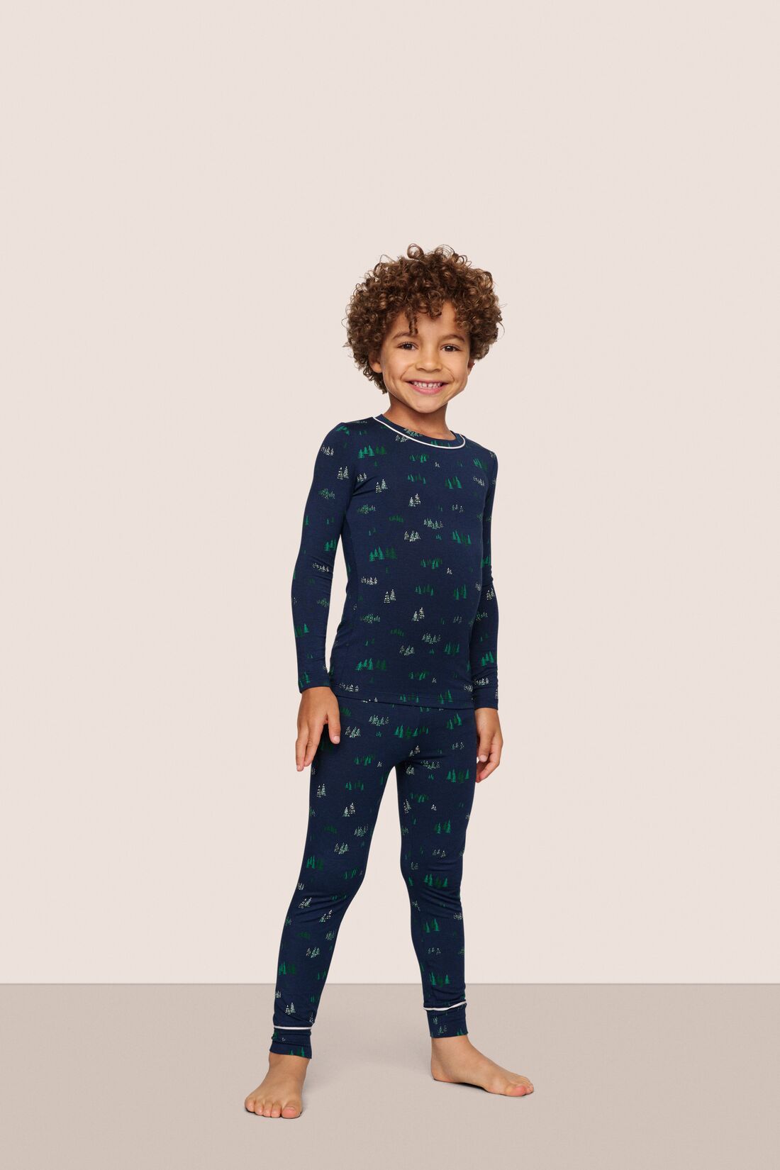 Model is wearing Kids Printed TENCEL Modal Unisex Long PJ Set  in Forest Pine Navy/Ivory