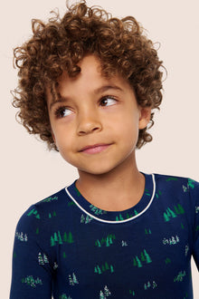 Model is wearing Kids Printed TENCEL Modal Unisex Long PJ Set  in Forest Pine Navy/Ivory