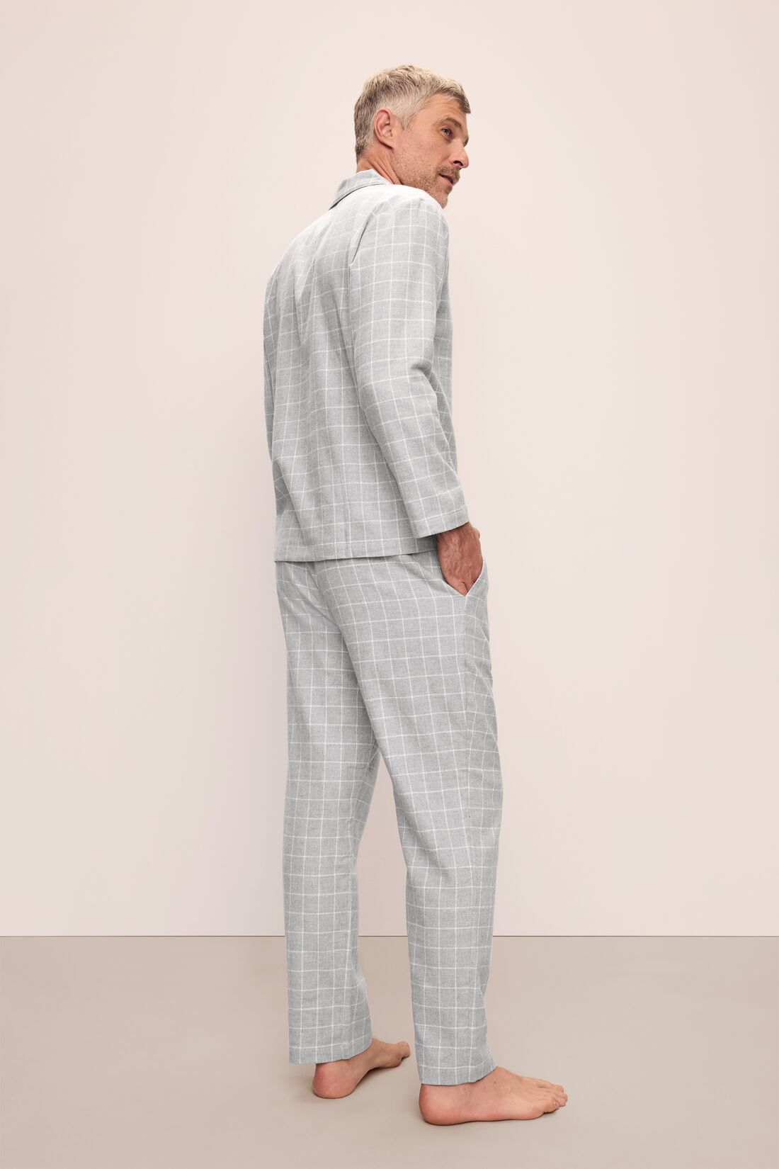 Model is wearing Men's Flannel Long PJ Set in Wintercheck Heather Grey/Ivory.