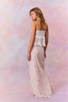 Maxi skirt featuring tiny beads that make up larger rhinestone-studded flowers dotting the skirt. Includes a side seam zipper and is finished with a slit at the wearerâ€™s left.