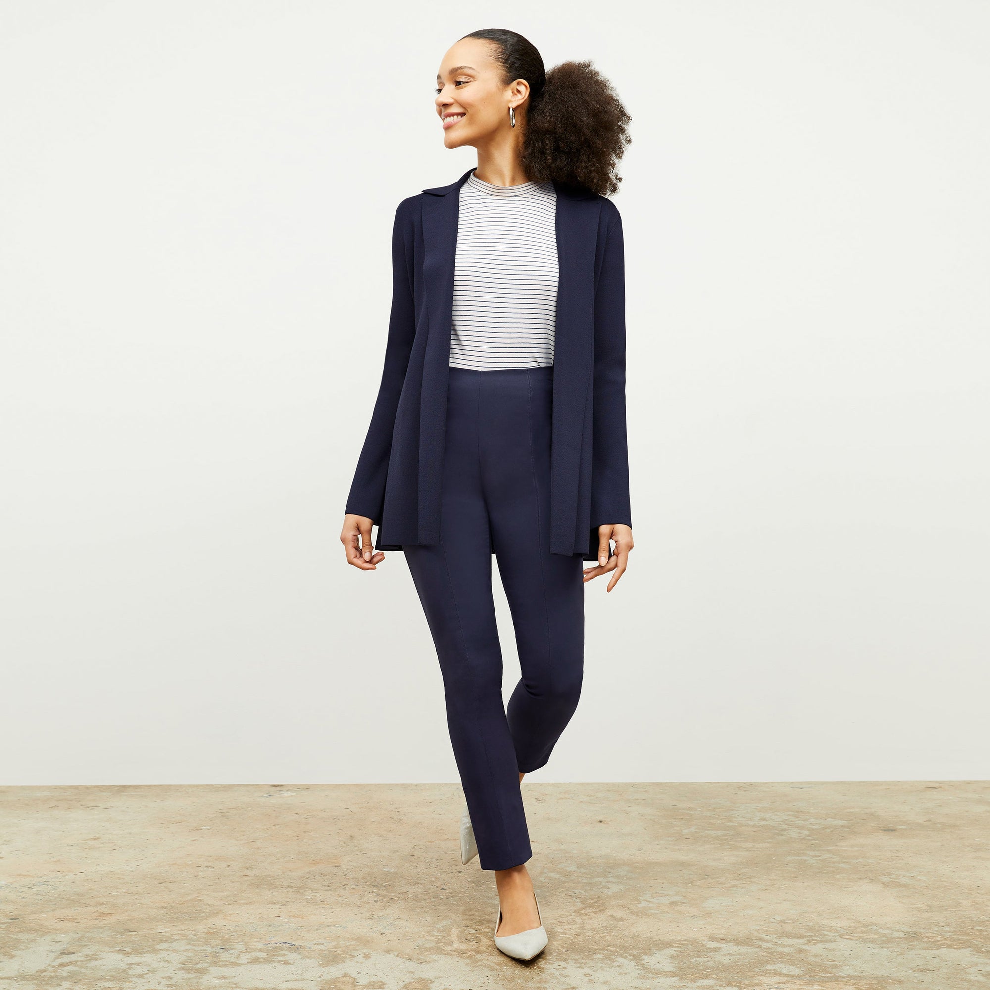 Front image of a woman standing wearing the foster pant in dark navy 