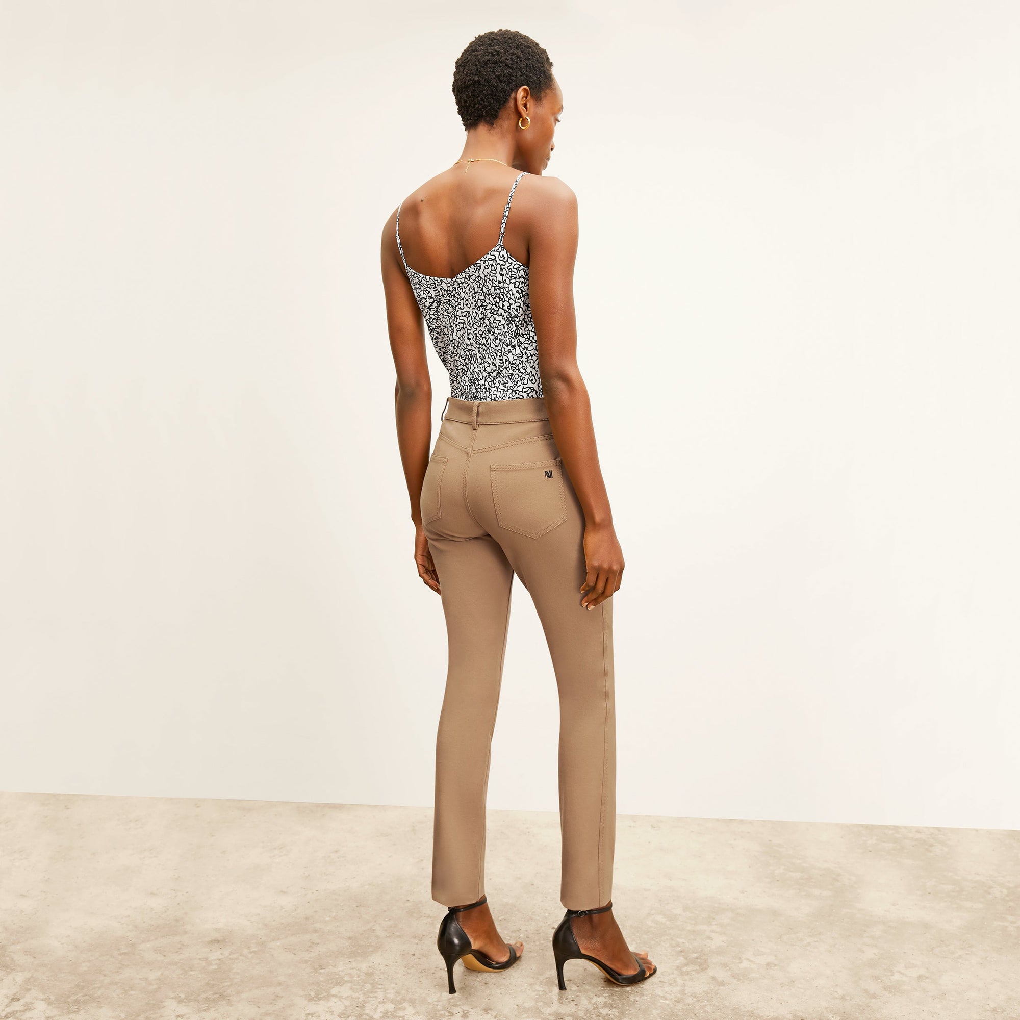 back image of a woman wearing the roma jean in saddle