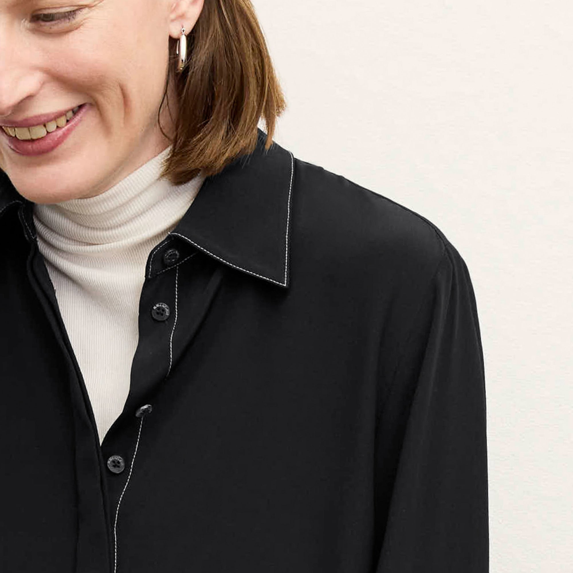 front image of a woman wearing the mira top in black
