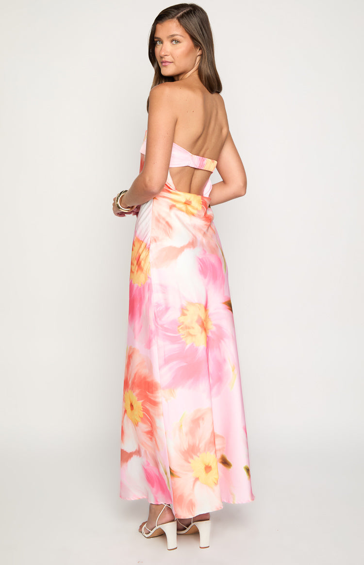 Rear view of a pink floral print maxi dress with a strapless back and waist cutout detail