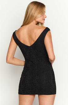 Close-up of the black lace V-neckline and the intricate floral pattern of the mini dress