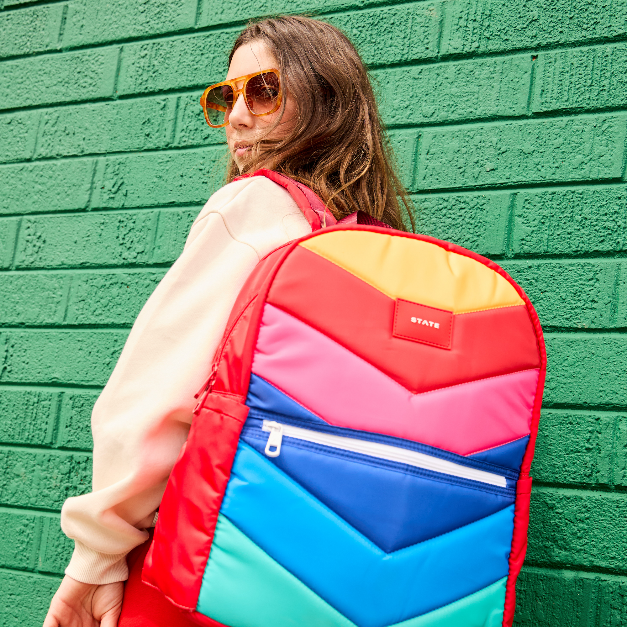 Girl wearing rainbow chevron backpack