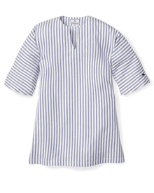 The Girls Twill Caftan in Navy French Ticking by Petite Plume is a blue and white vertical striped dress crafted from breathable cotton. It features elbow-length sleeves, a V-neckline, and a mid-thigh hemline, offering a tunic-like appearance reminiscent of luxurious sleepwear.