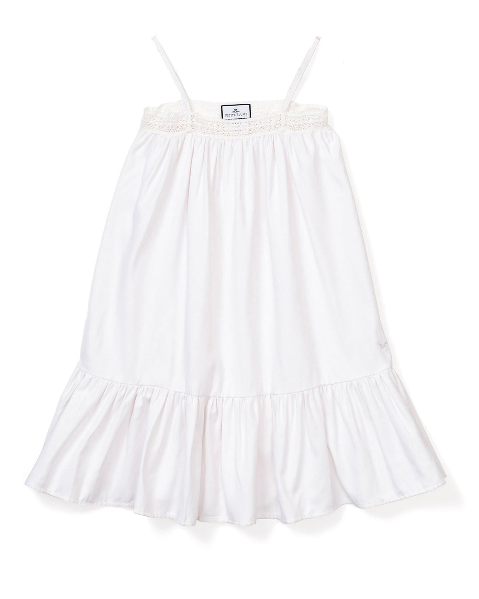The Girls Twill Lily Nightgown in White by Petite Plume is sleeveless with thin straps, a smocked bodice, and a ruffled hem. Made from yarn-dyed cotton, its light and flowing, perfect for warm weather.