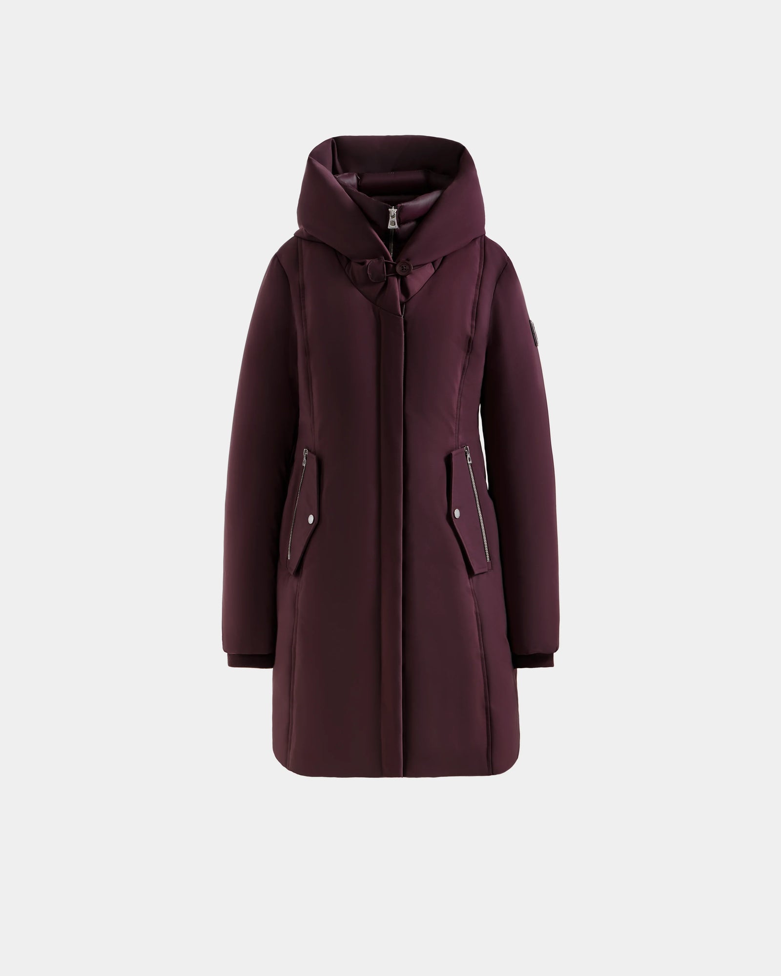 The Rudsak SARINA - L125550 Bordeaux is a long, dark burgundy women’s down parka with a hood, front zipper, snap buttons, and two zippered front pockets, shown on a plain light gray background.