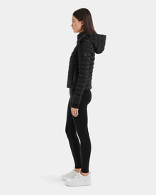 A woman wears the Rudsak MARYA M - L123559 Black womens down puffer.