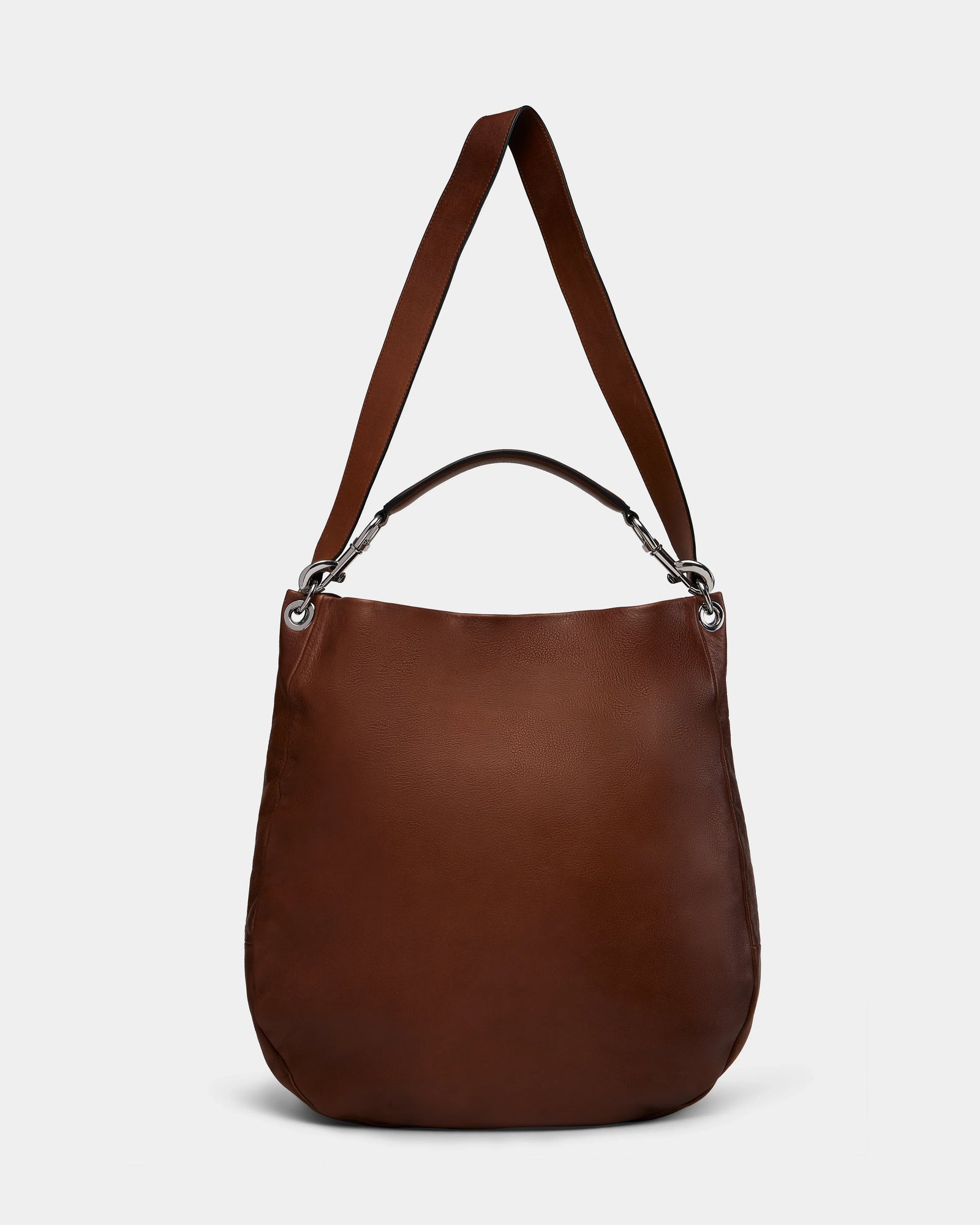 The Rudsak VIKA - 8325036 Mocha is a brown leather shoulder bag with a wide strap, silver hardware, and a minimalist rounded design, stylishly showcased against a plain white background.