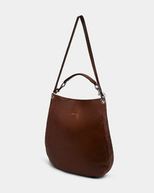 The Rudsak VIKA - 8325036 Mocha is a women’s brown hobo shoulder bag with silver hardware, short handle, and long adjustable strap, shown against a plain white background.