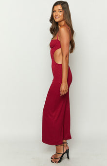 Side view of a red ribbed maxi dress with a bustier top and waist cutouts