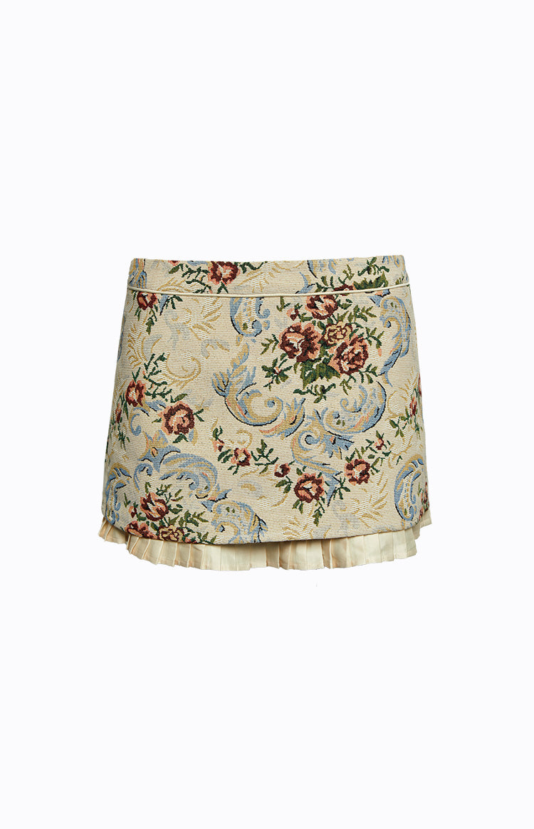 Front view of a beige tapestry mini skirt with red and blue floral pattern and pleated hem