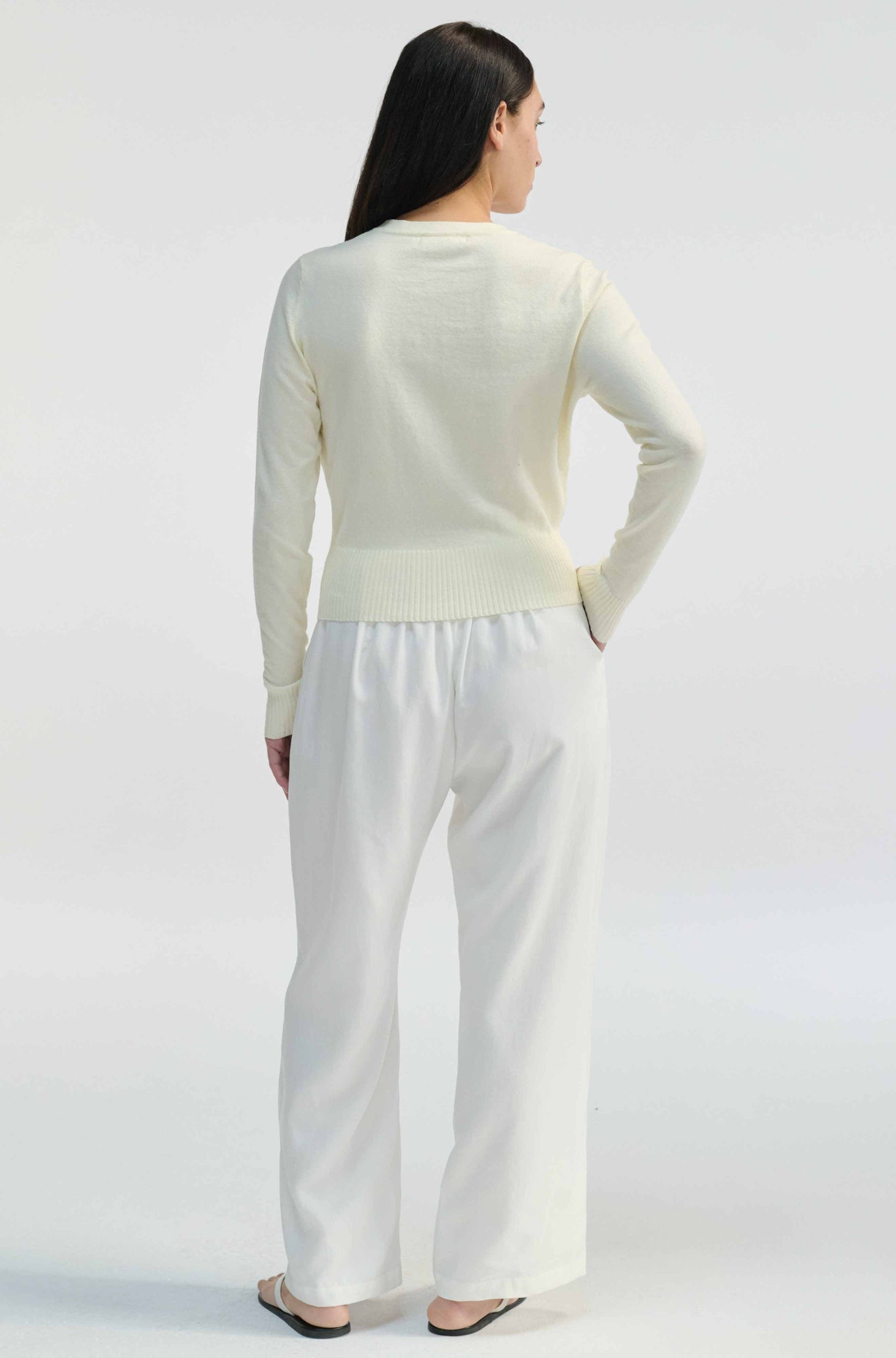 Woman wearing a white outfit on a plain background