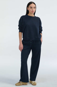 Woman wearing a navy blue outfit on a white background
