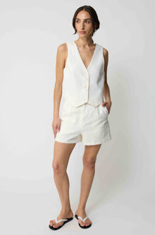 Woman wearing a white tencel vest and white linen shorts