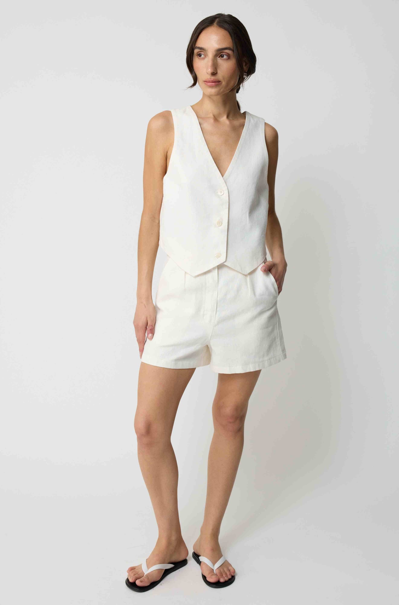 Woman wearing a white linen vest with matching white linen shorts