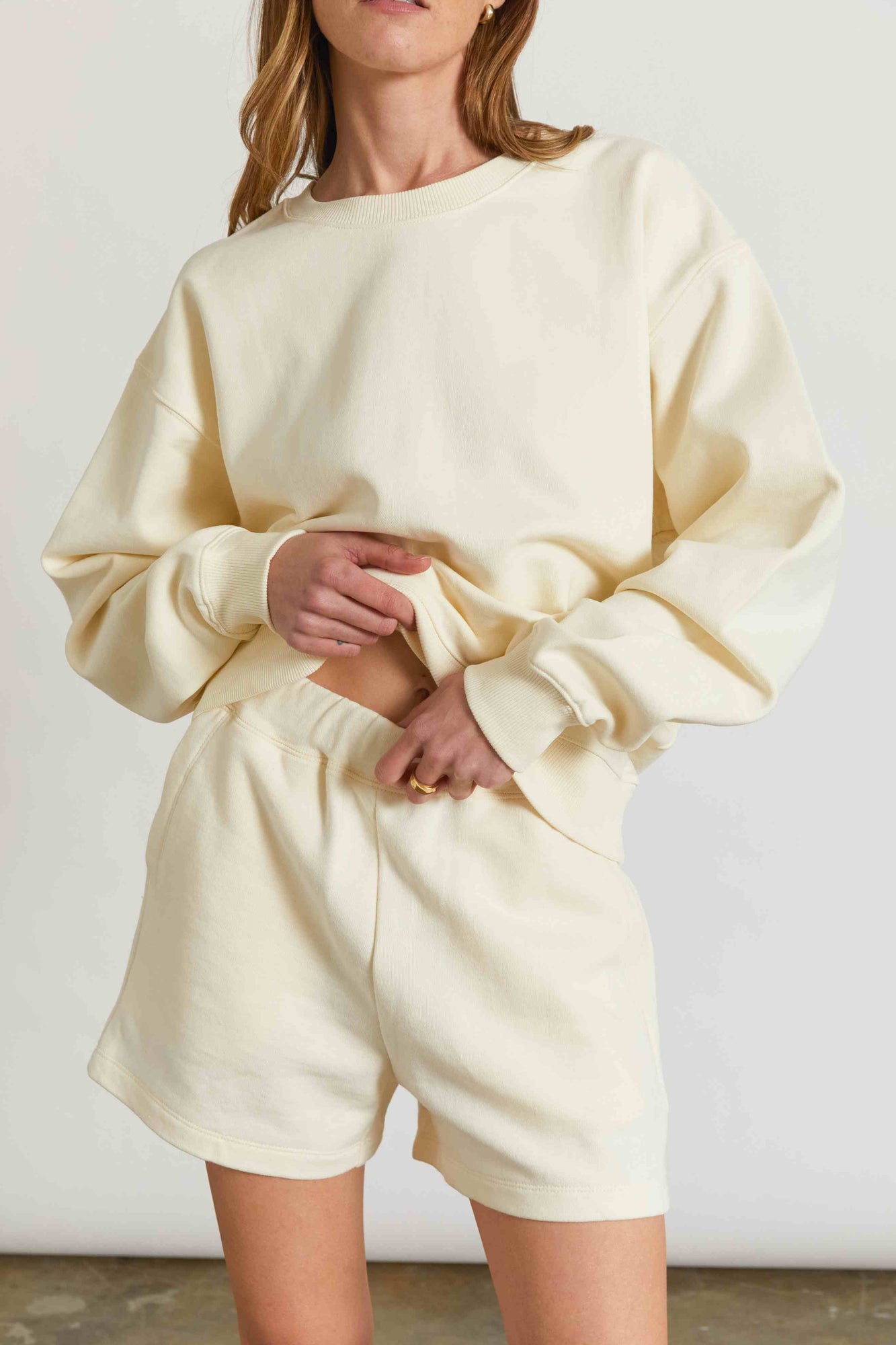 Woman wearing a yellow sweatshirt and matching sweatshorts