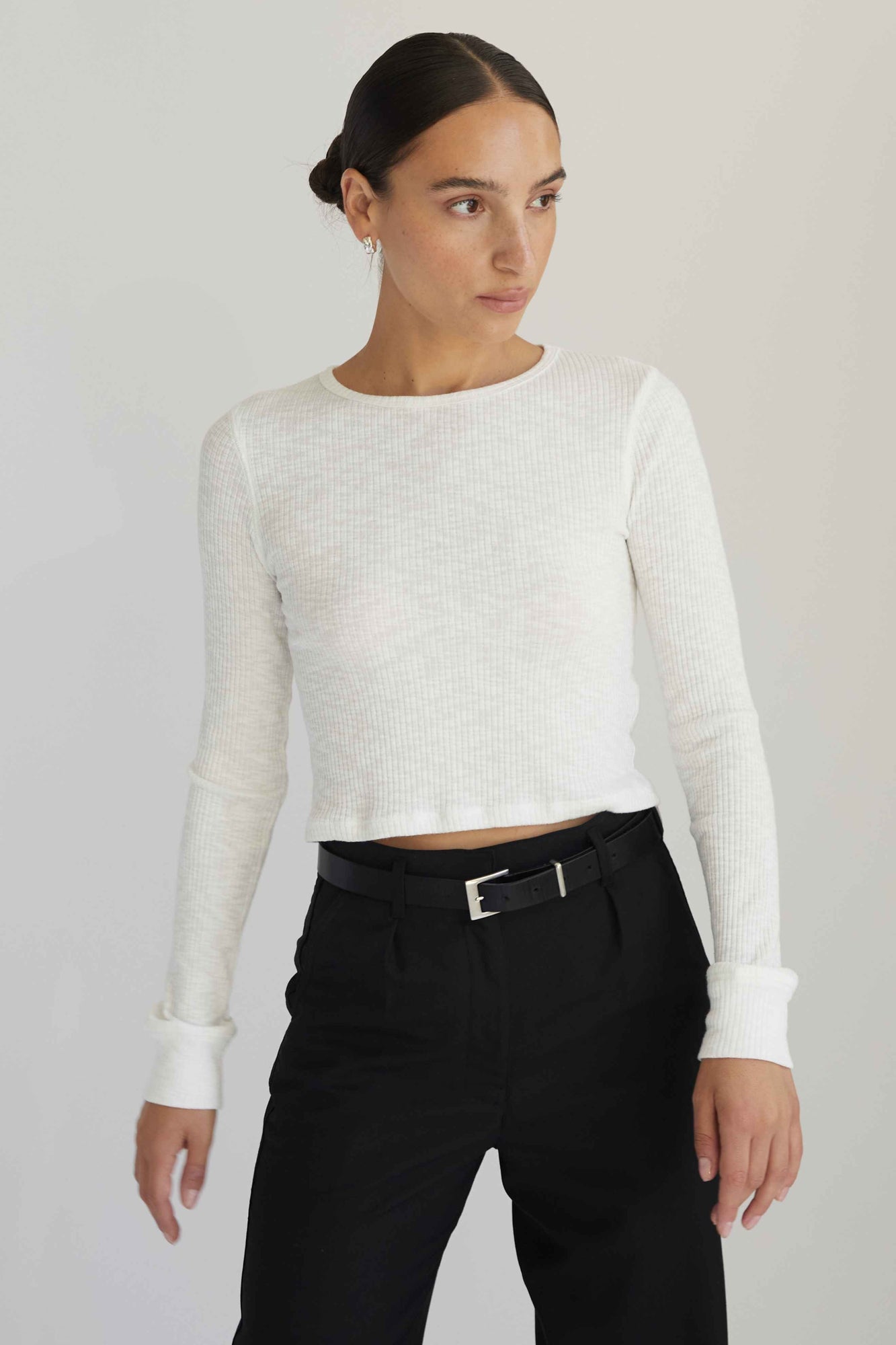 Woman wearing a white long sleeve top with black pants