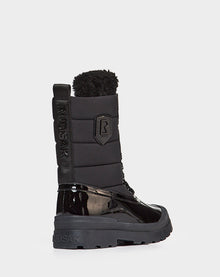 The Rudsak LEX - 8222501 BLACK is a women’s winter boot featuring a shiny patent leather lower, quilted upper, thick sole, side branding, pull tab, fuzzy top lining, and is stylishly waterproof for winter wear.