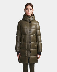 A woman faces forward against a plain light background, wearing the Rudsak MEYA S - L123521 Light Olive women's quilted down puffer with a removable hood, large buttons, and deep front pockets.