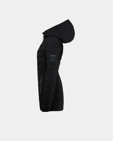 The Rudsak COSETTE - L124004 Black is a women’s fitted down jacket with a hood, matte fabric, zipper pocket, and patch logo on the upper sleeve. Shown side view against a plain light background.