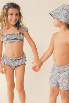 Child wearing blue paisley bucket hat and matching swimwear, shown from front and side angles.