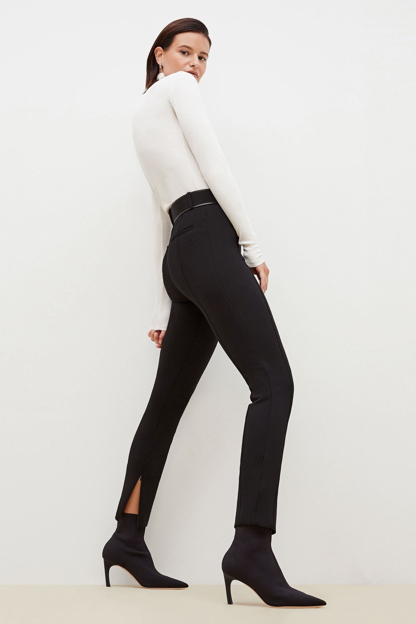 Side image of a woman standing wearing the Curie Pant--Worth in Black | Grid | Exclude