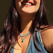 Shimmering beaded opal necklace made of smooth opals in shades of blue on a gold slim lobster clasp layered with a apatite slim gemstone necklace and acorn charm