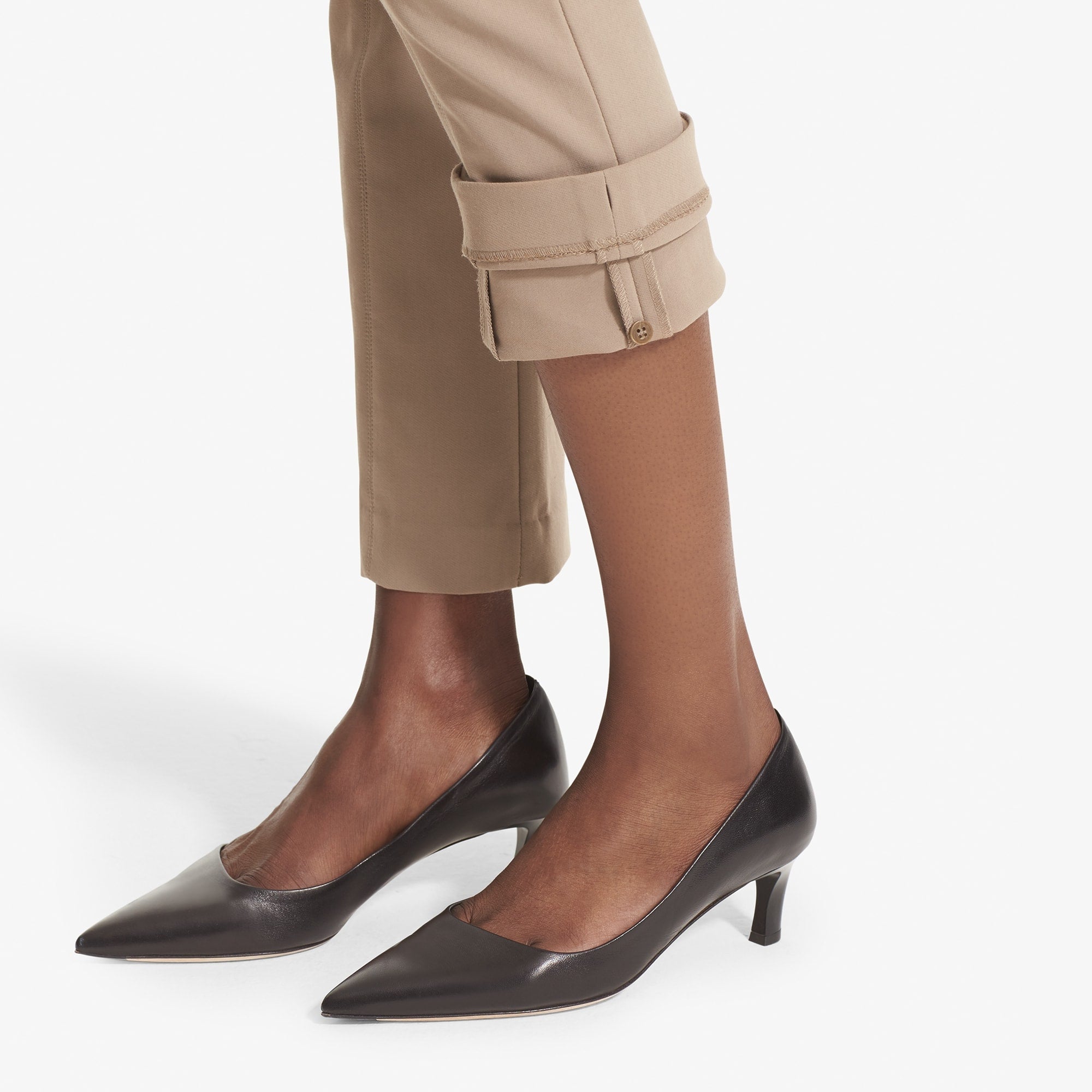 Detail image of a woman standing wearing the Foster Pant in Russet showing the inside button to self hem the pant | Exclude