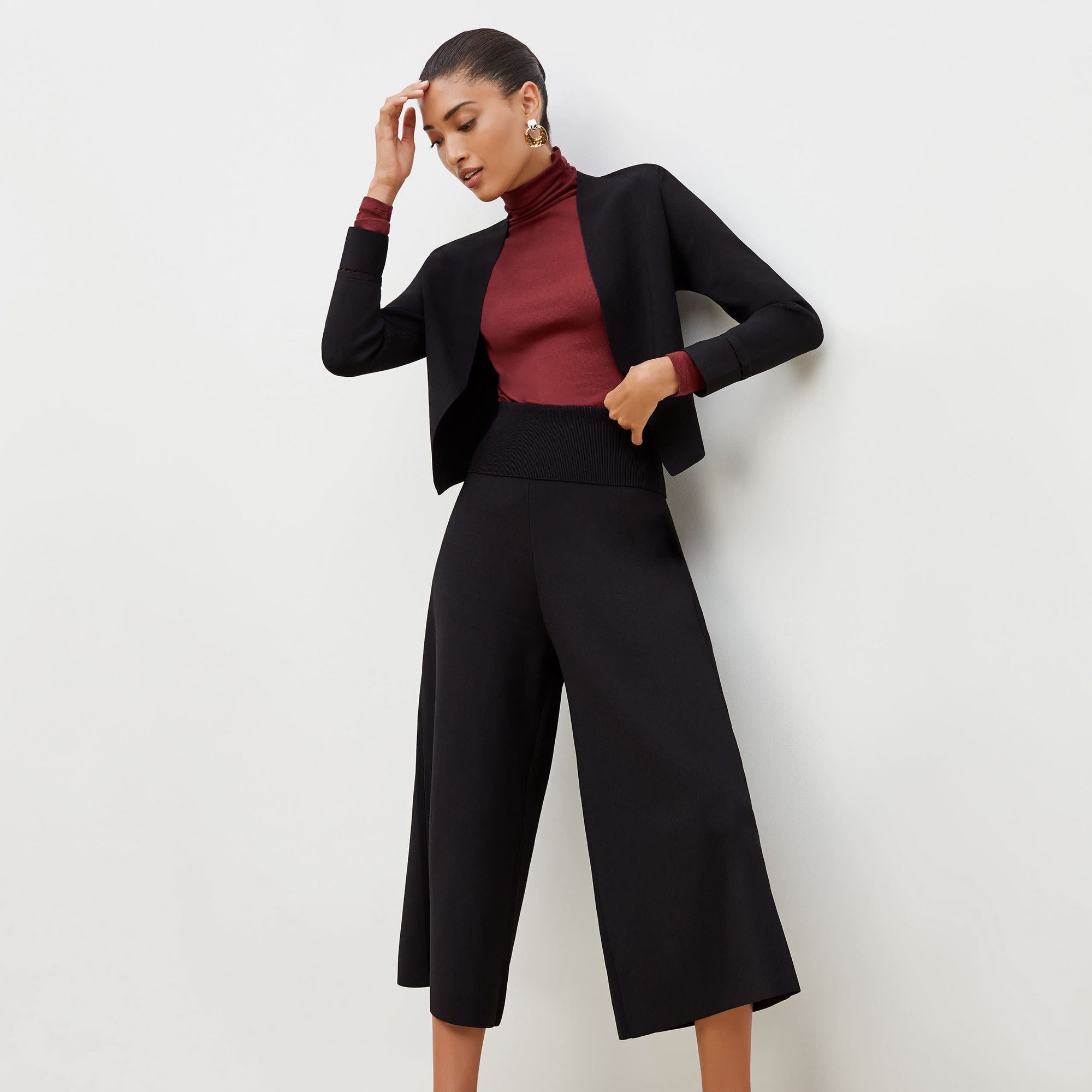 Front image of a woman standing wearing the Sant Ambroeus jardigan in black | Exclude